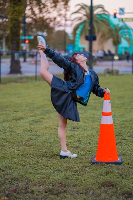 Woman in a white top performing a gentle yoga pose in a park
